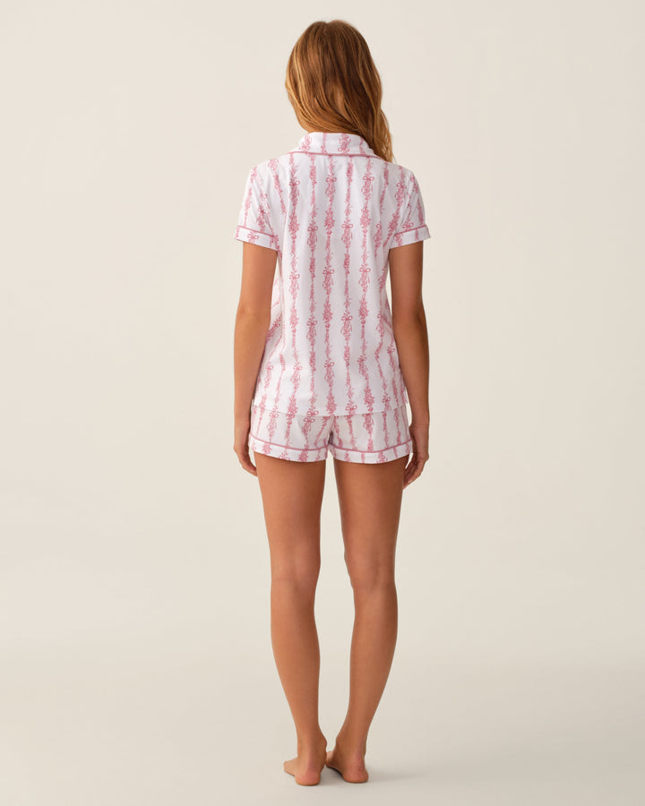 Back side of woman wearing pink and white pajama set