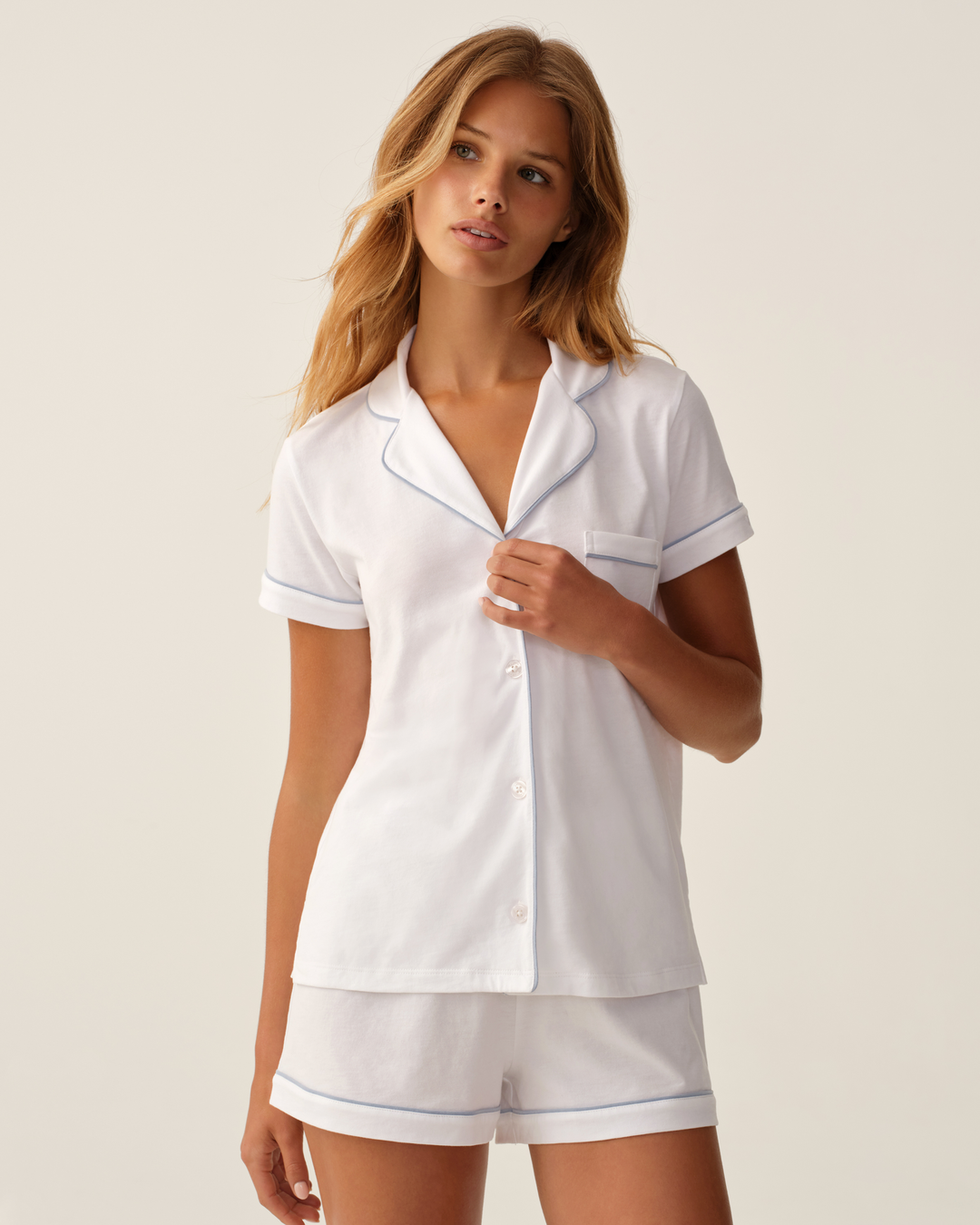 woman modeling white with blue trim pajama set