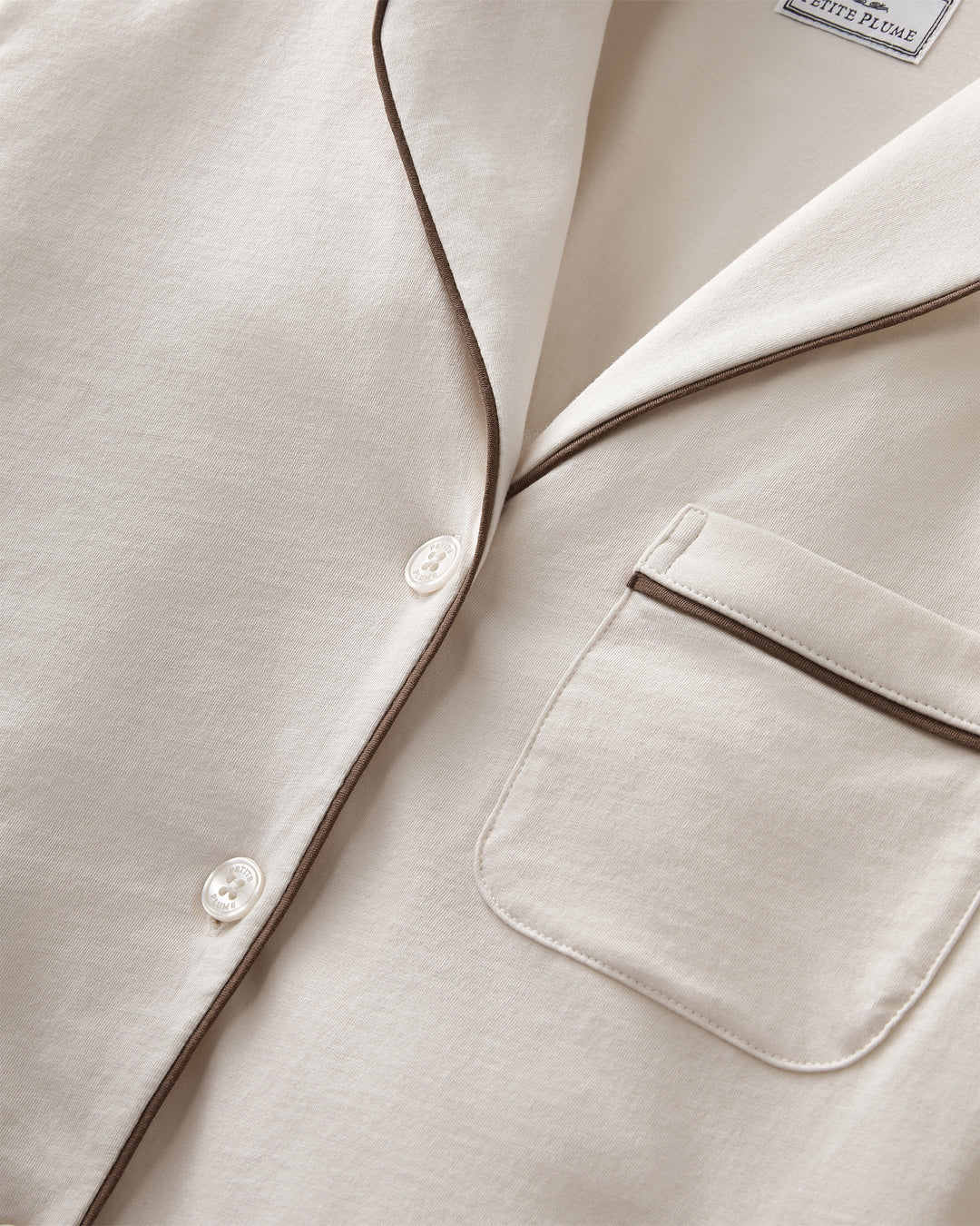 Close up on ivory pajama set with brown piping