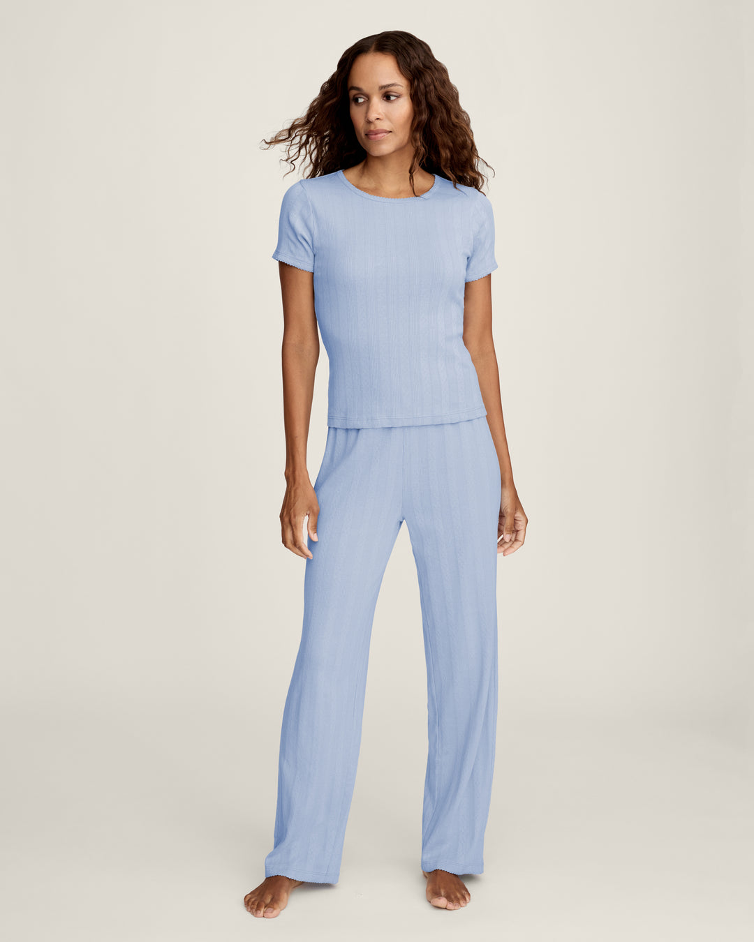 Woman wearing a light blue pajama set on a white background