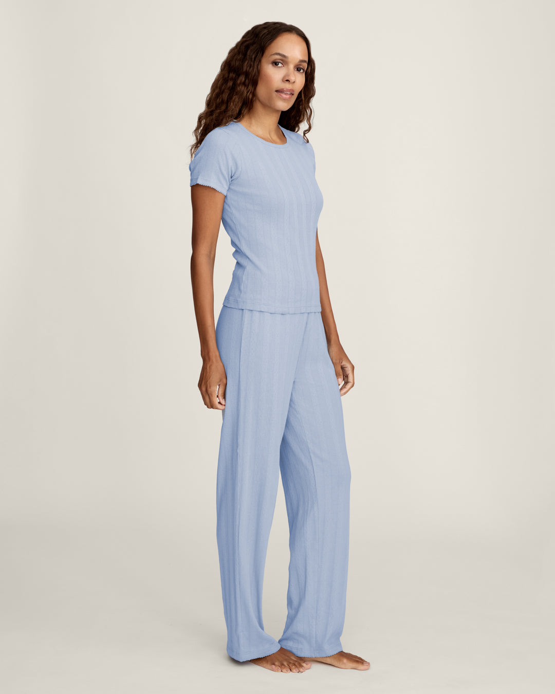 Woman wearing a light blue outfit on a white background