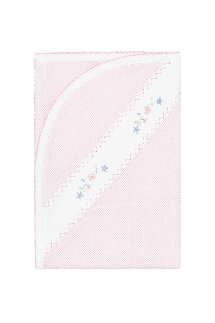 A folded baby blanket in light pink and white with a herringbone pattern, featuring a diagonal white stripe with delicate embroidered floral details in pink, blue, and yellow.