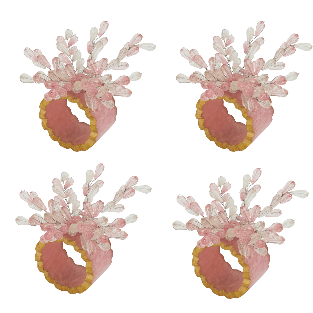Four pink and white coral-themed napkin rings on a white background