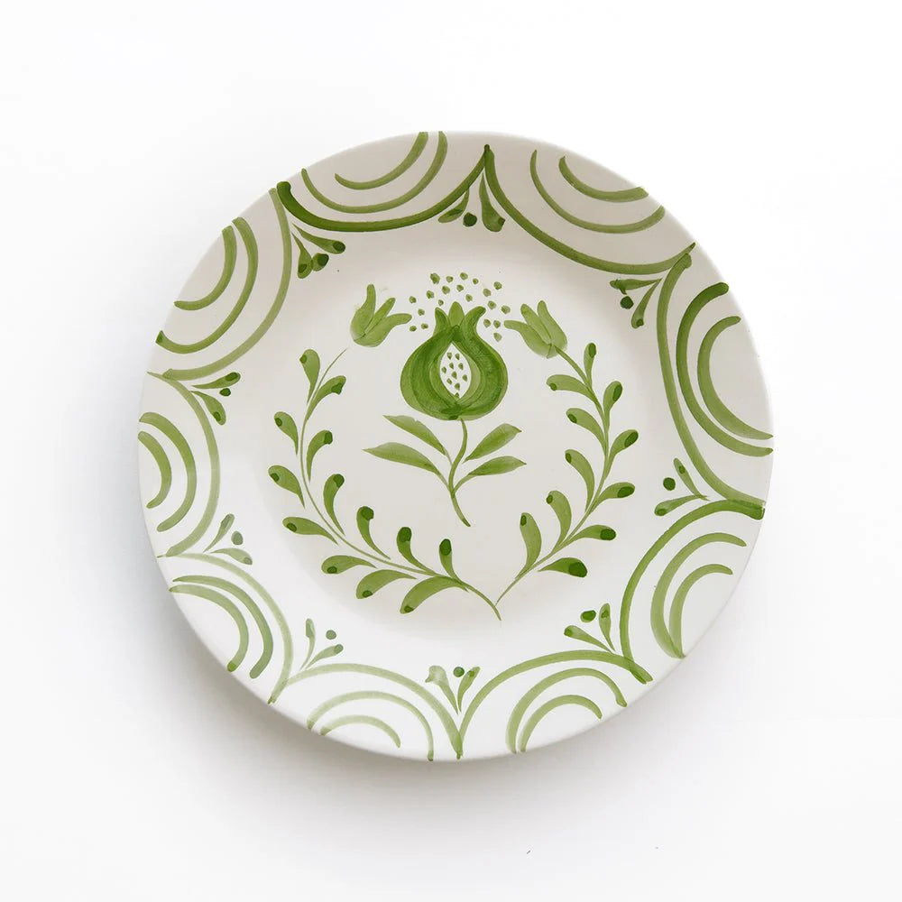 Decorative plate with green floral and pomegranate design on a white background