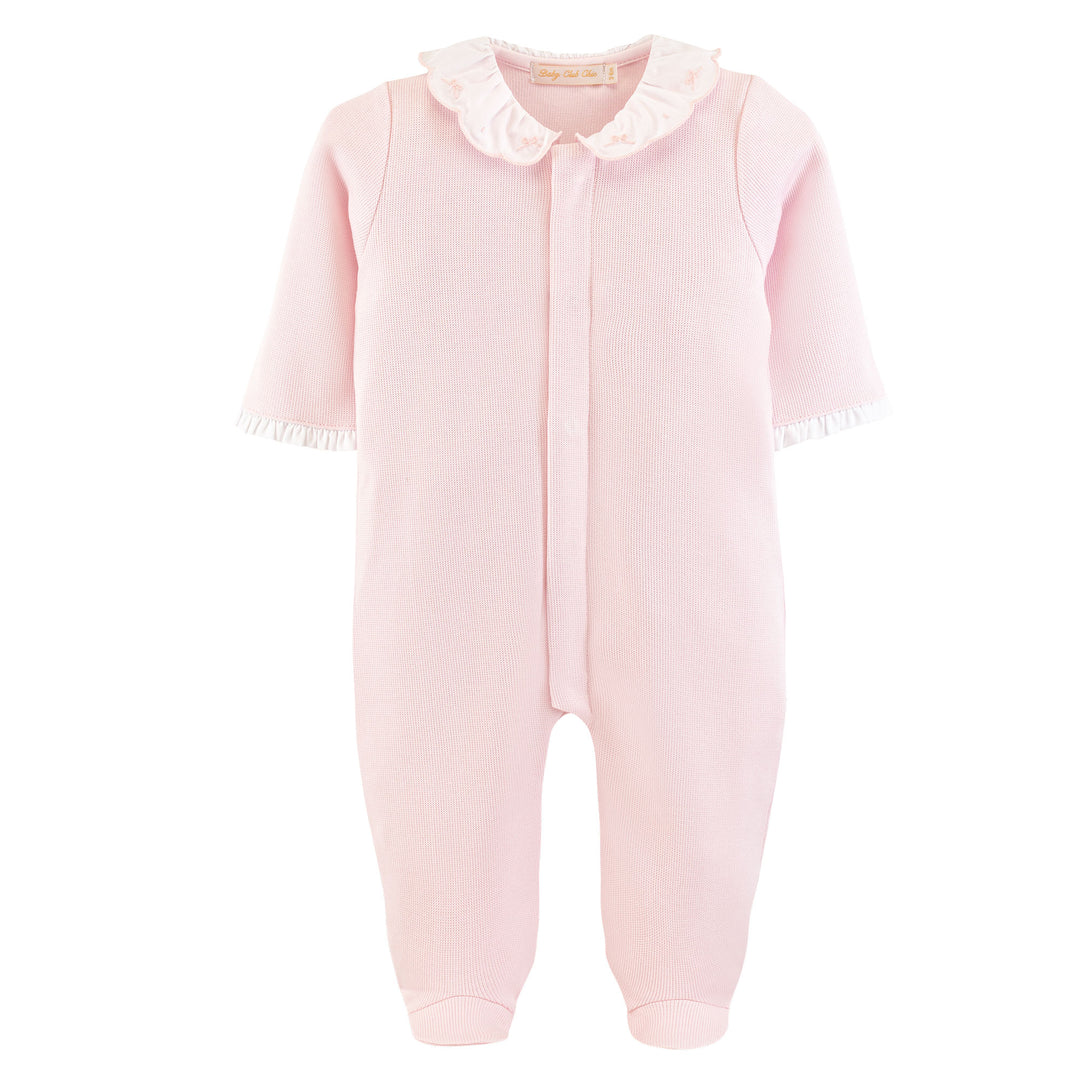 A light pink baby footed jumpsuit with a ruffled collar and short sleeves, shown against a plain white background.