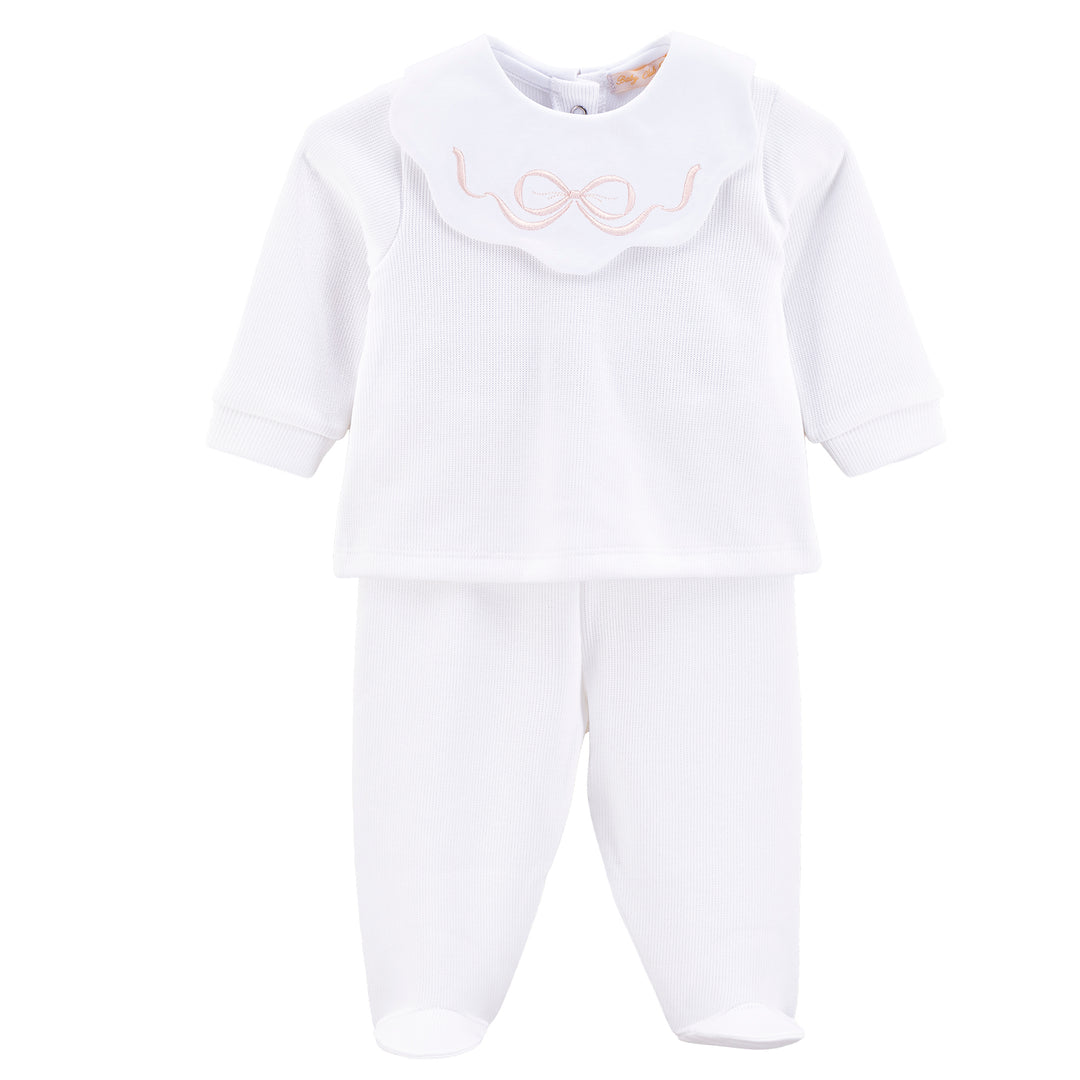 A white baby sleepwear set consisting of a long-sleeve top with a scalloped Peter Pan collar featuring a light pink embroidered bow, paired with matching white footed pants, shown on a plain white background.