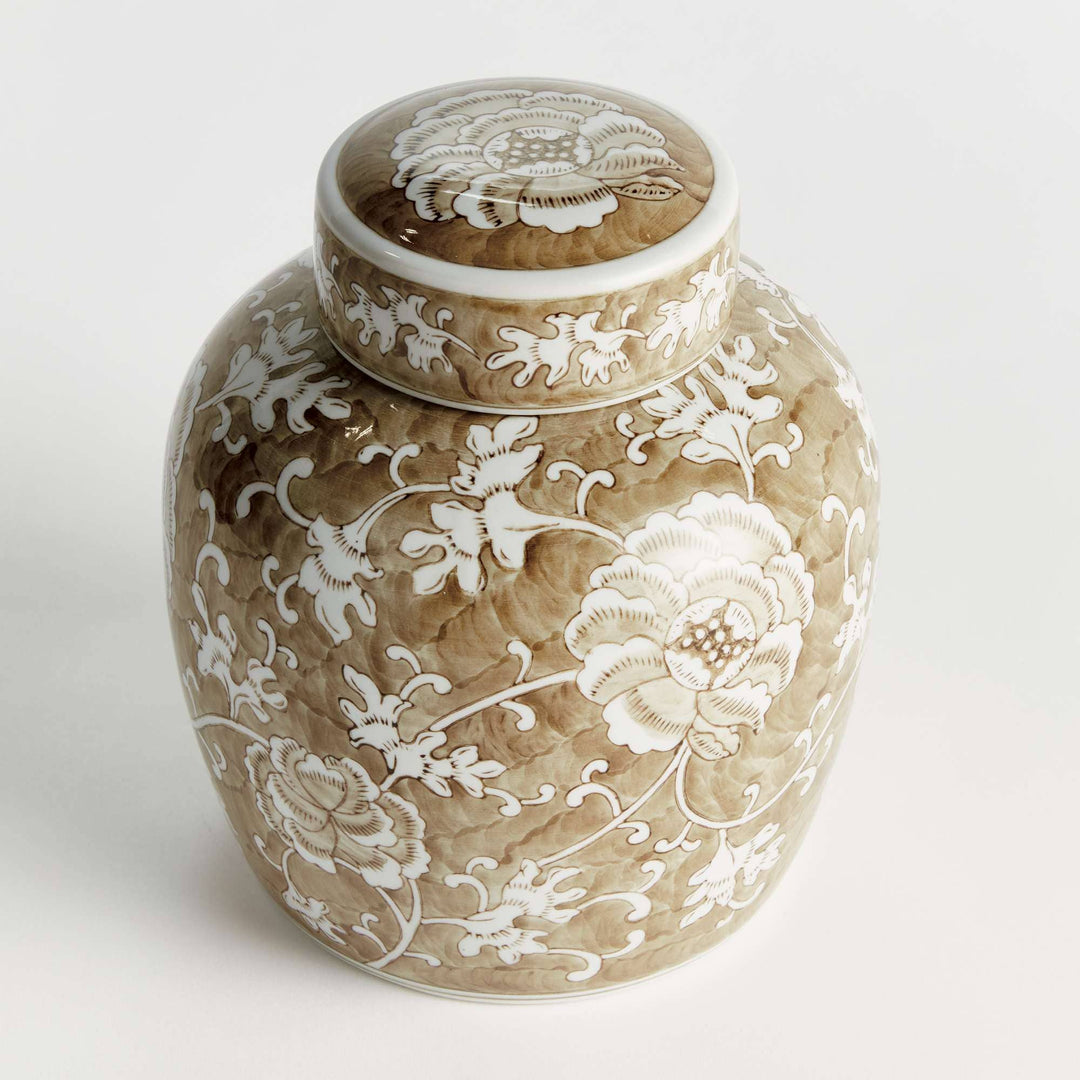 Decorative ceramic jar with white floral patterns on a light background
