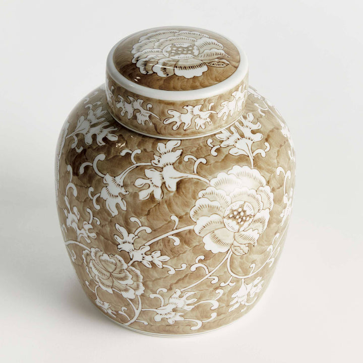 Decorative ceramic jar with white floral patterns on a light background