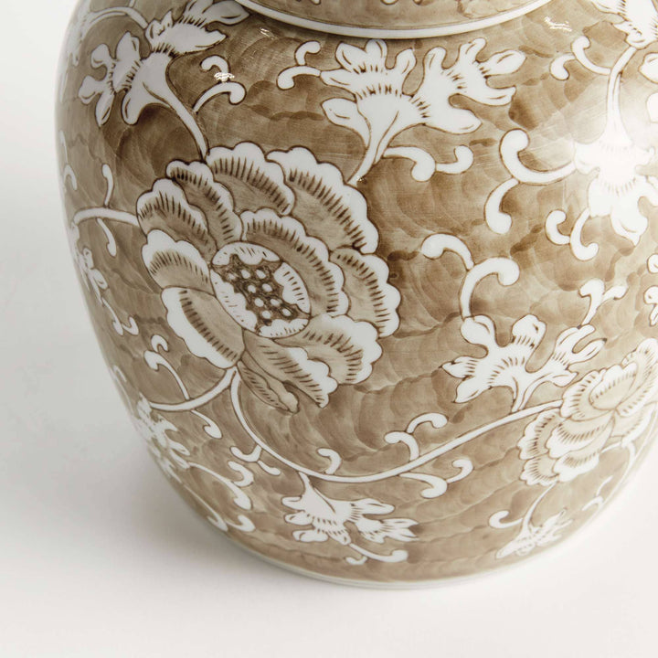 Ceramic jar with intricate white floral patterns on a beige background