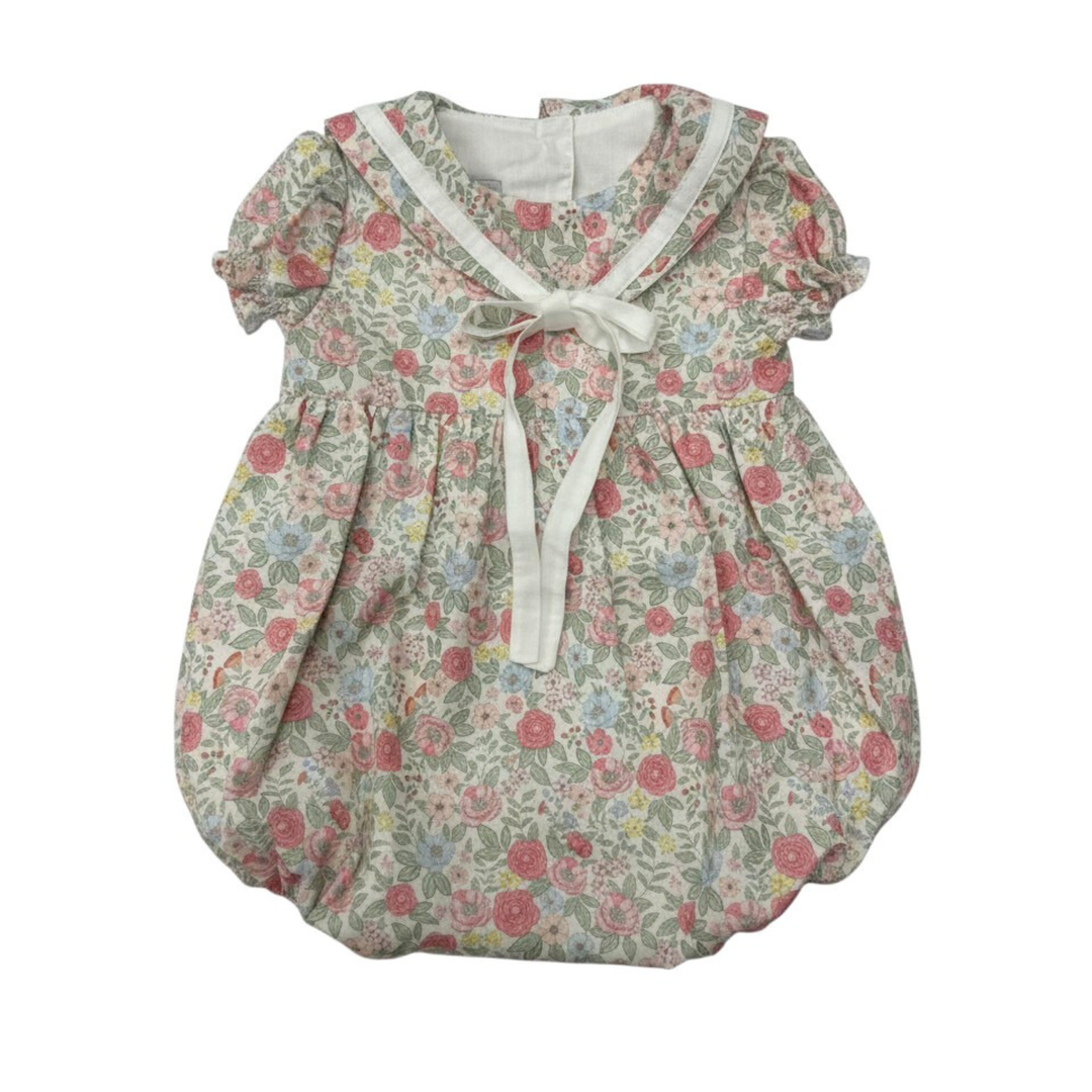 Floral baby dress with a white ribbon on a white background