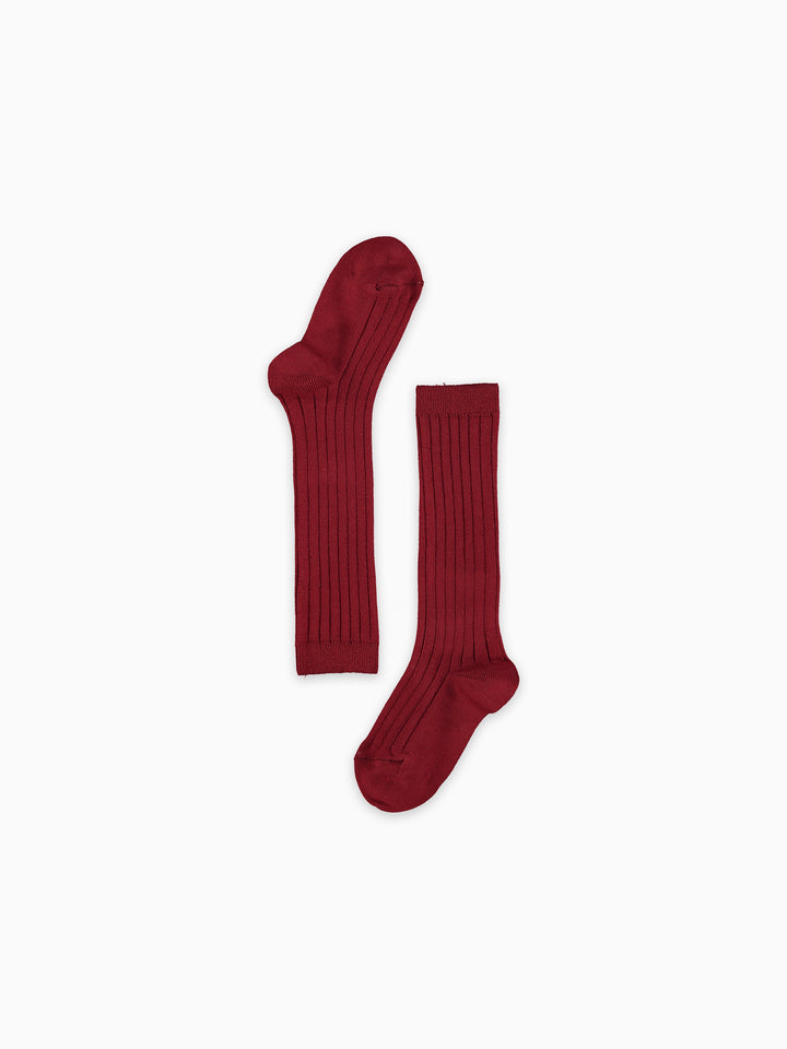 A pair of dark red ribbed knee-high socks laid flat on a clean white background.