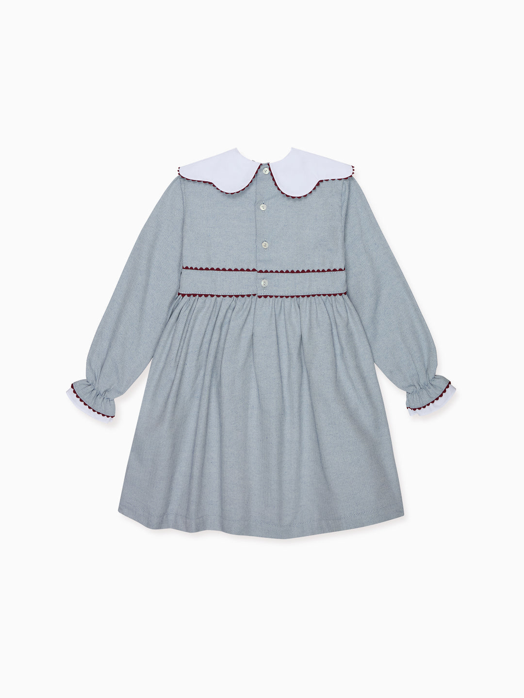 A light blue long-sleeve dress for toddlers, featuring a contrasting white Peter Pan collar with red trim, a buttoned front, and a matching red-trimmed waistband.