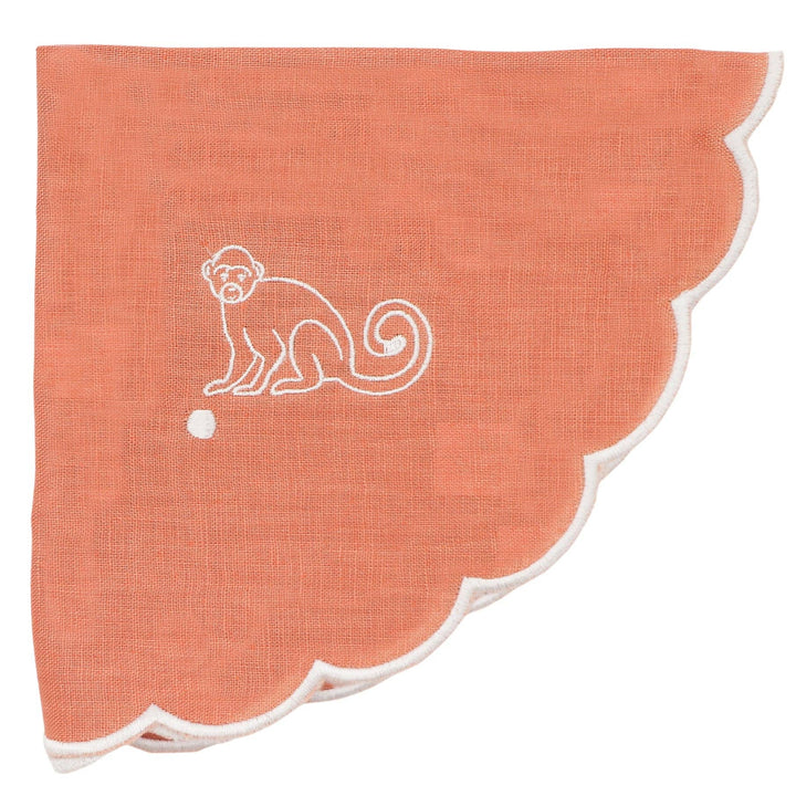 Coral-colored fabric with a white monkey design on a white background