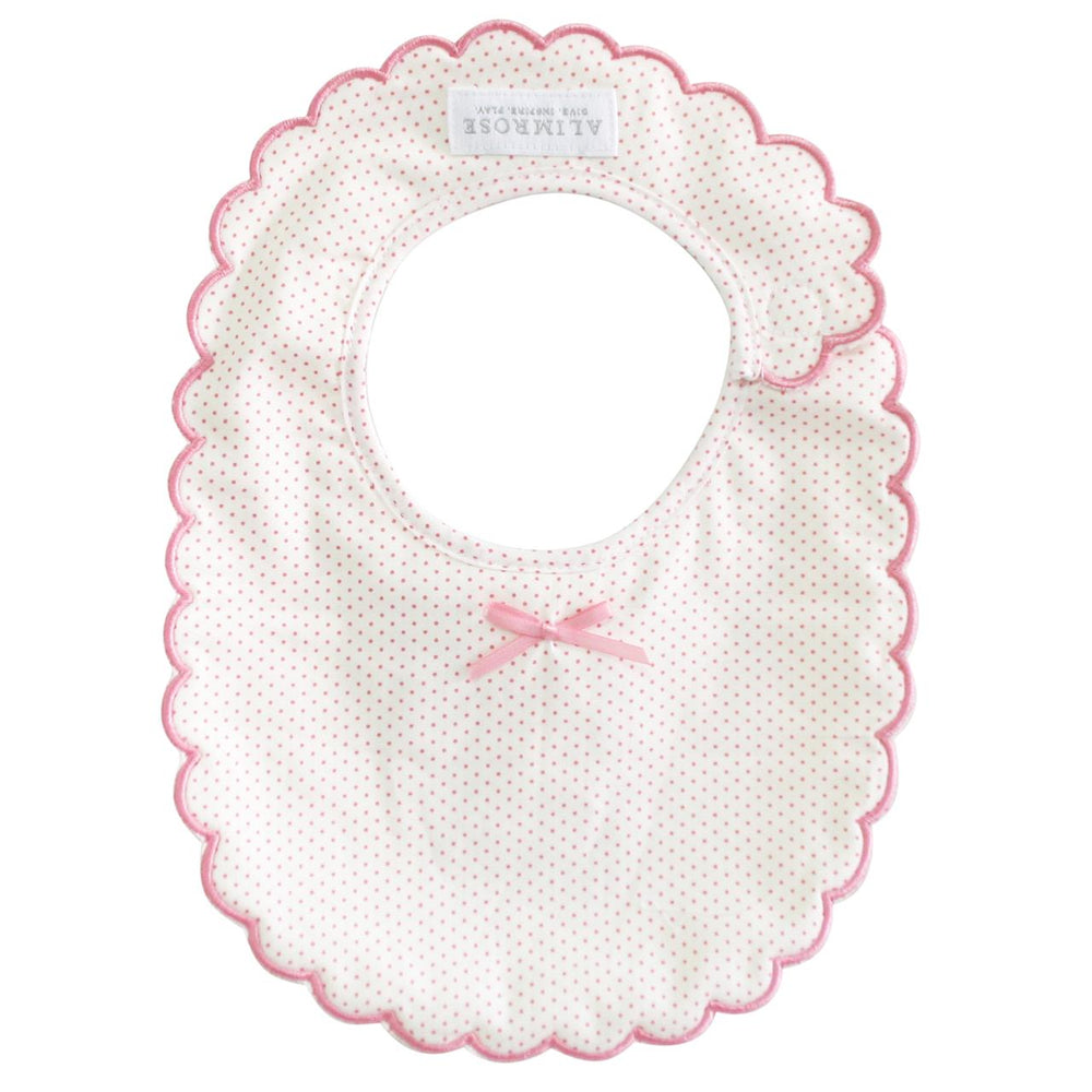 Baby bib with scalloped edge and pink bow on a white background