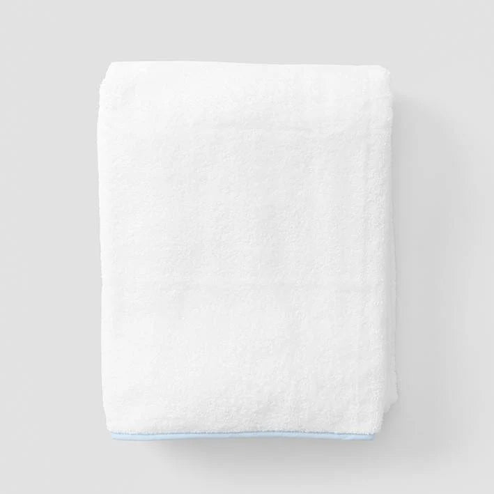 White towel with a light blue border on a gray background