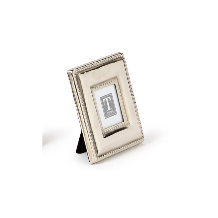 A small rectangular silver picture frame with a decorative beaded border and a black easel stand, shown on a plain white background.