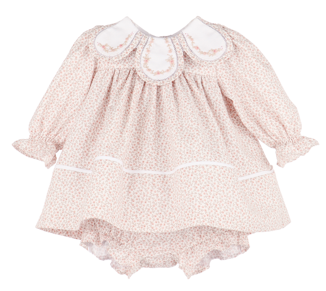 Baby dress with floral pattern and white collar on a white background