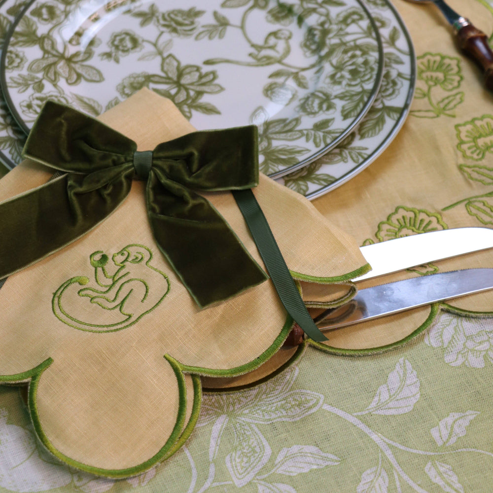 Decorative plate with green ribbon and emblem on a patterned tablecloth