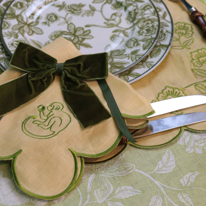 Decorative plate with green ribbon and emblem on a patterned tablecloth