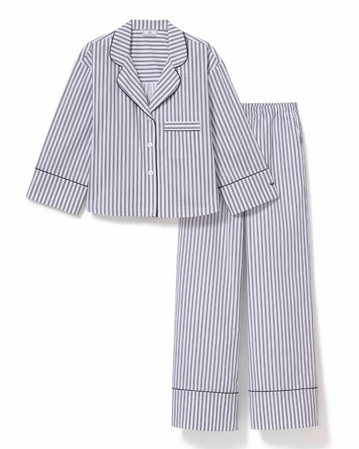 A two-piece pajama set featuring a long-sleeve button-front top and matching pants, both in a vertical blue and white stripe pattern with dark piping details.
