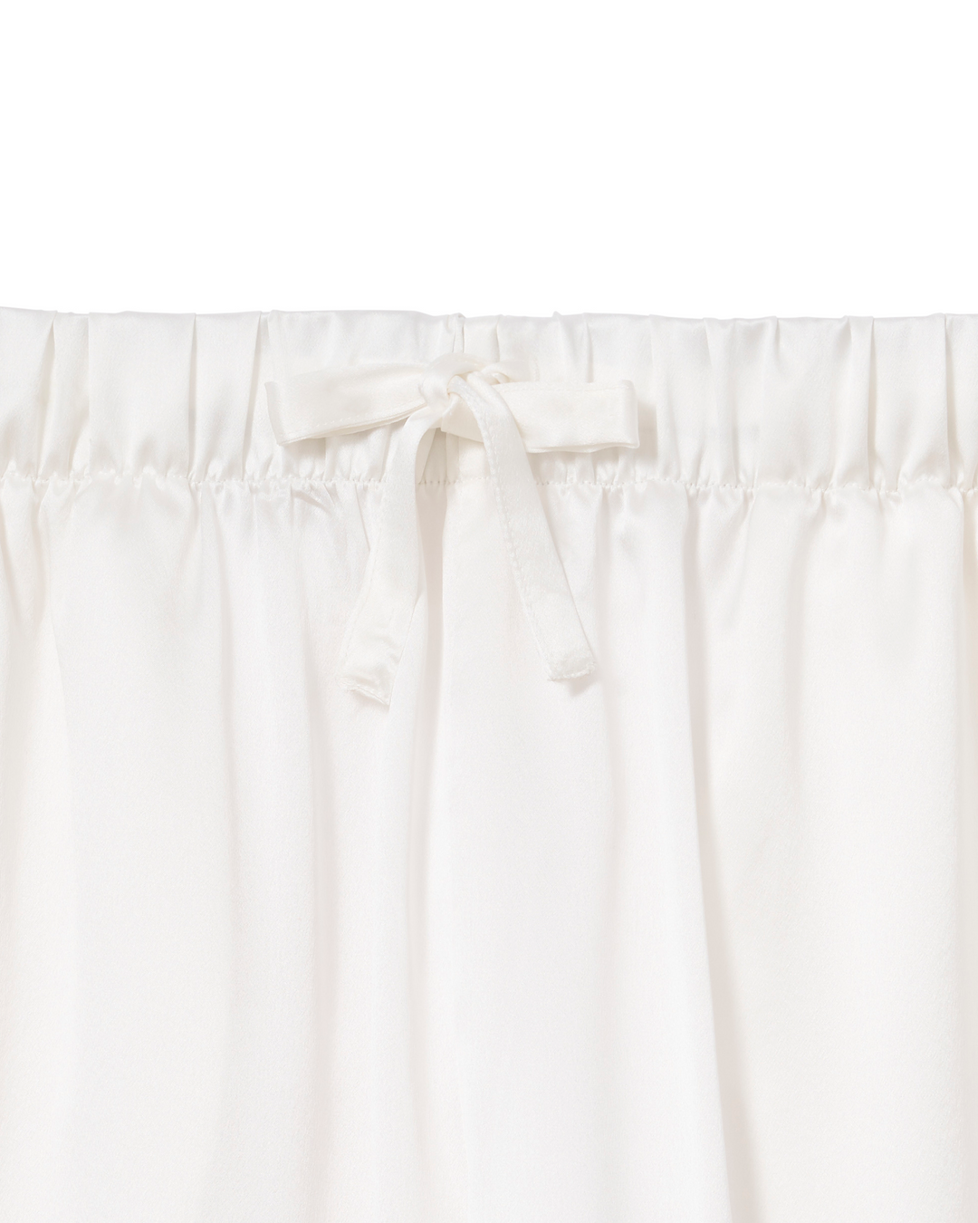 Close-up of a white or off-white gathered fabric with an elastic waistband and a small bow detail at the center front.