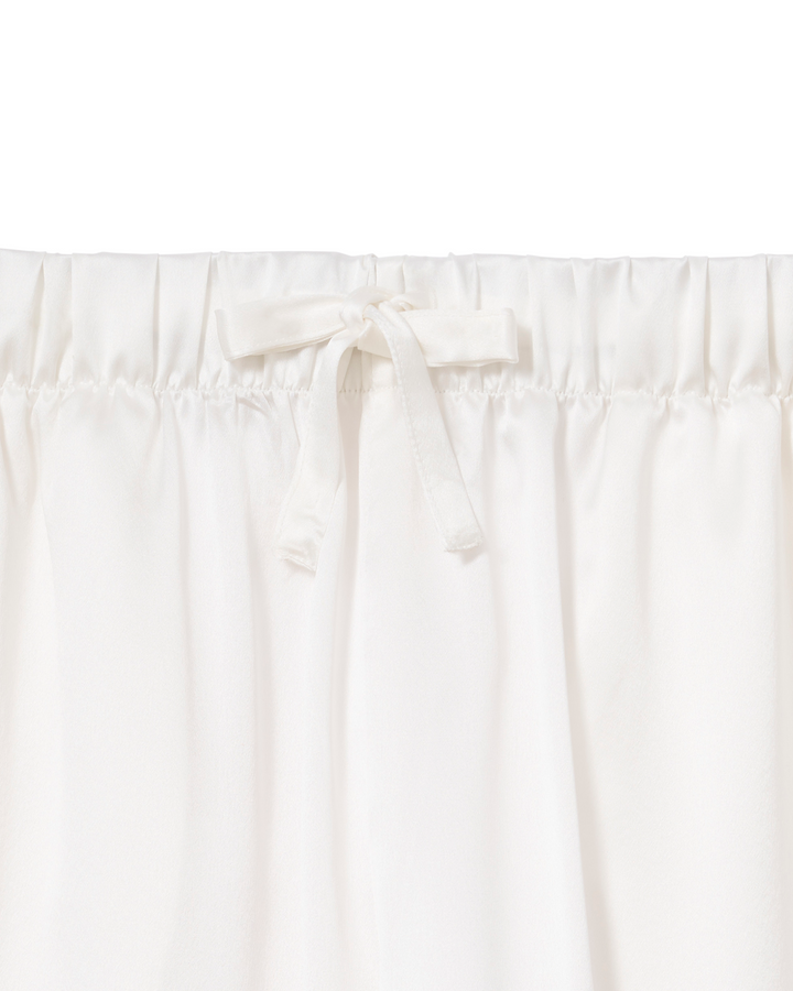 Close-up of a white or off-white gathered fabric with an elastic waistband and a small bow detail at the center front.