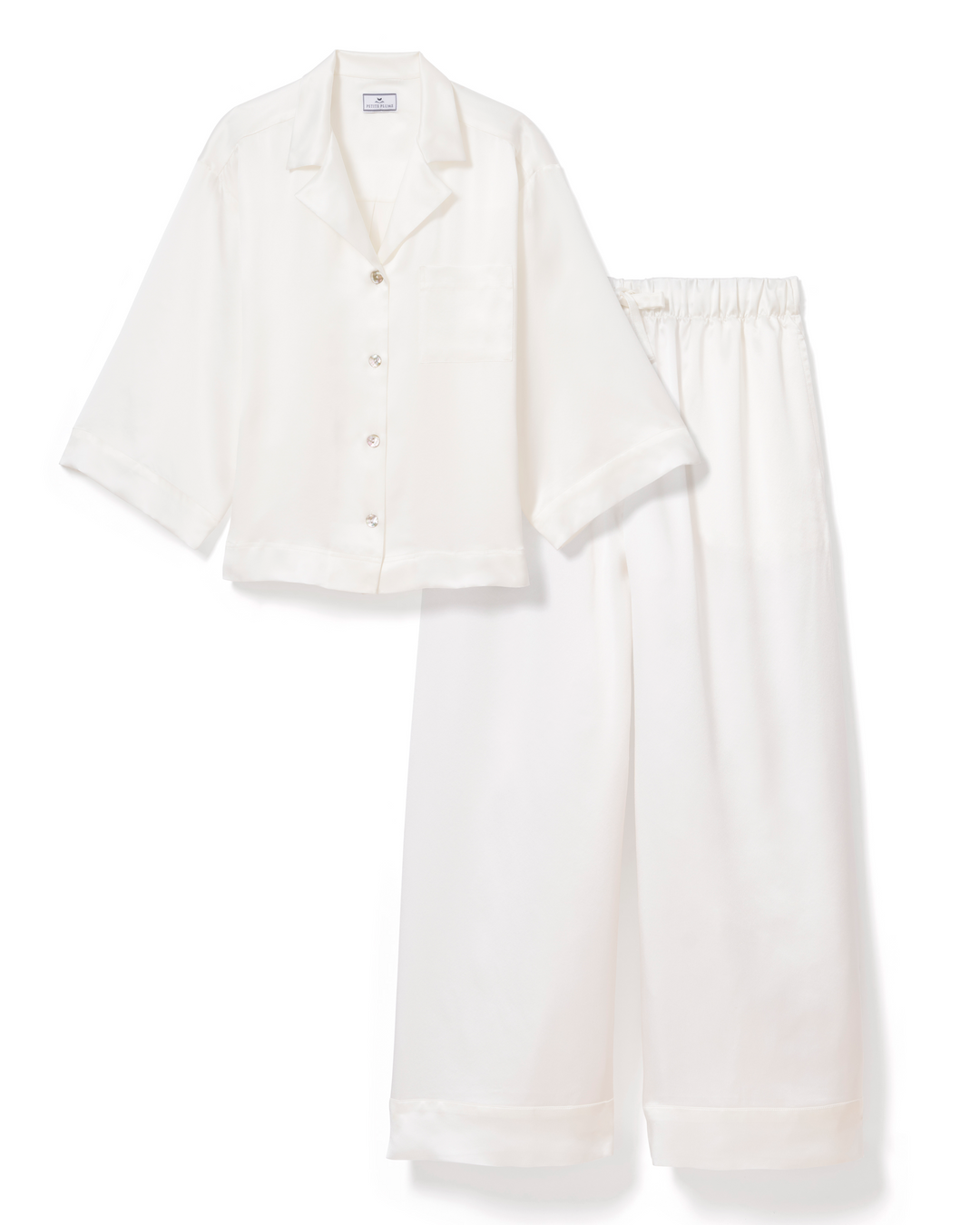 An off-white two-piece pajama set consisting of a short-sleeve button-front shirt and matching wide-leg pants, laid flat on a white background.