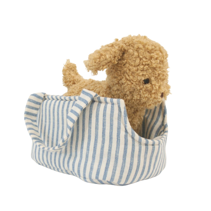 Plush puppy in a blue and white striped bag on a white background