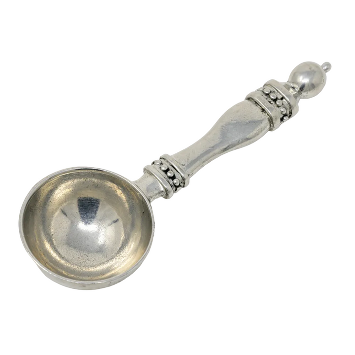 Silver scoop with decorative handle on a white background