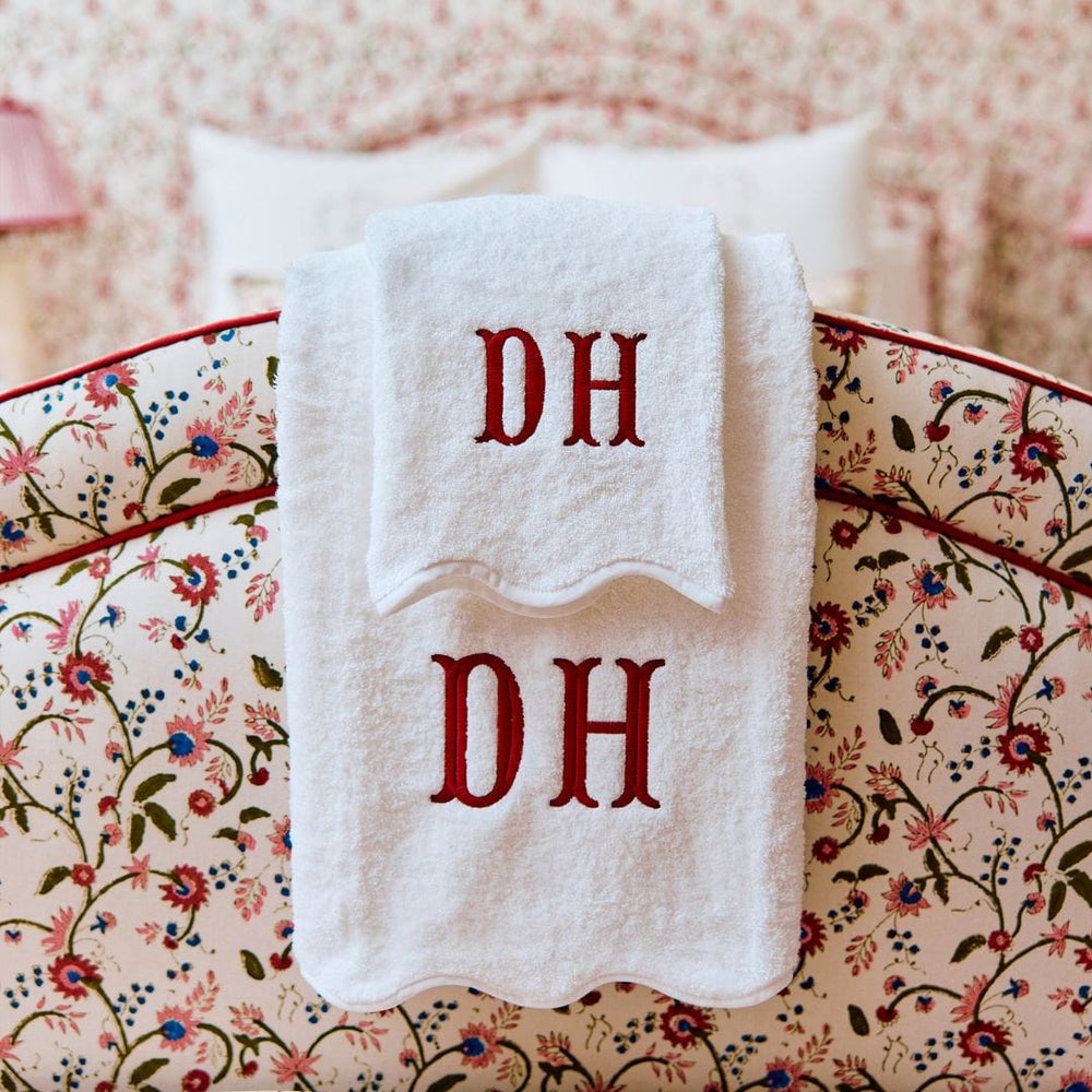 White towels with 'DH' monogram on a floral-patterned surface