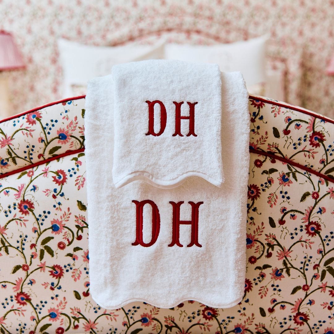 White towels with 'DH' monogram on a floral-patterned surface