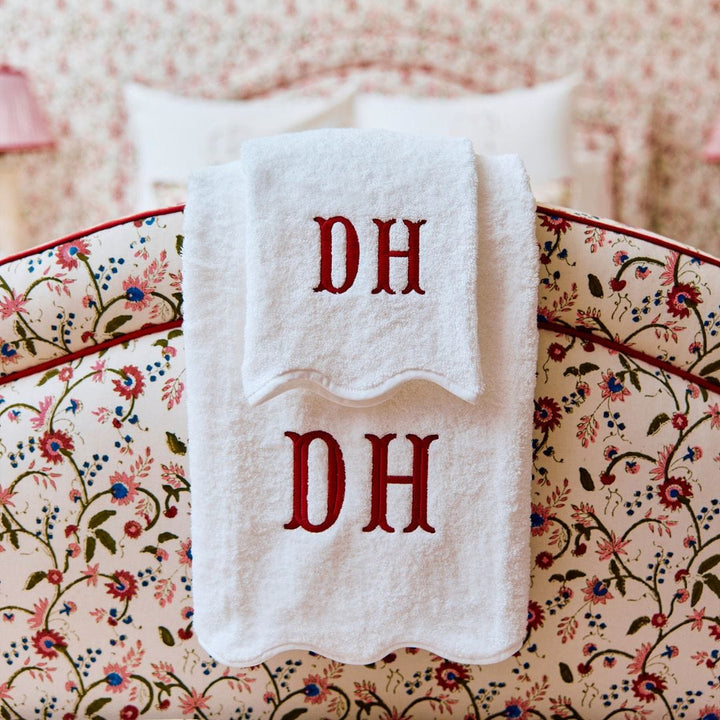 White towels with 'DH' monogram on a floral-patterned surface