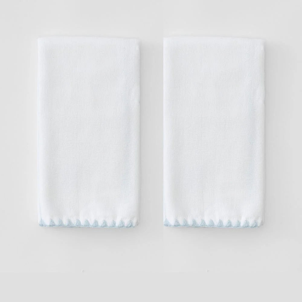 Two folded powder towels with blue stitched shell hem