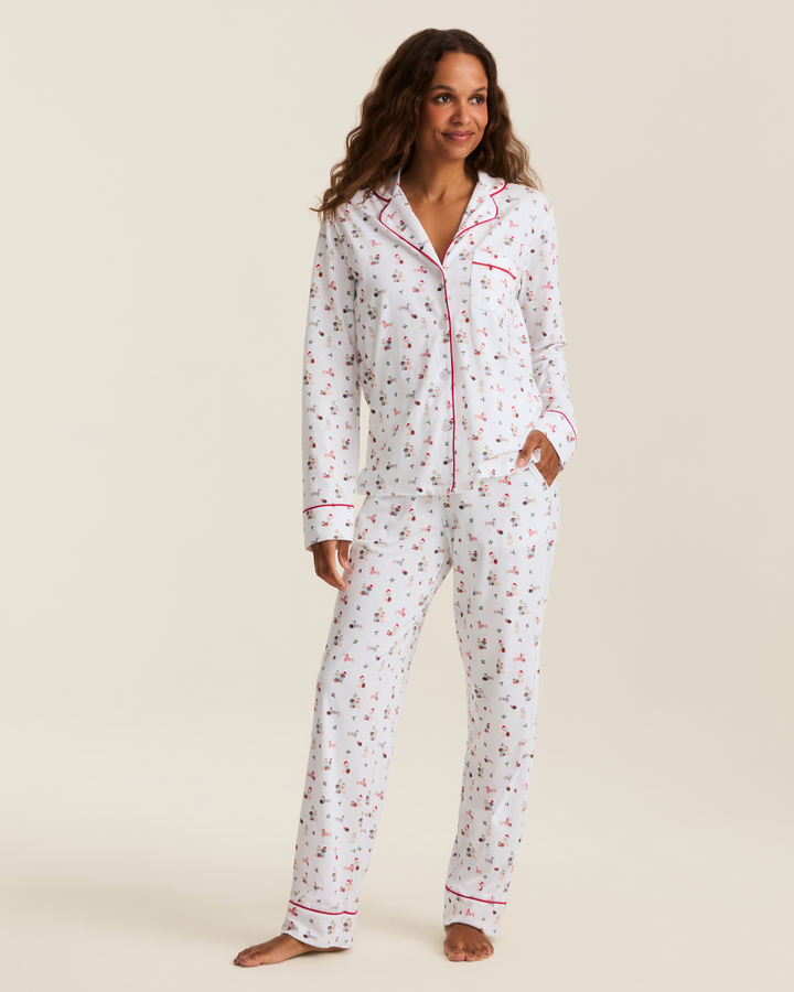 A woman wearing a 2 piece pajama set with a cute puppy motif print