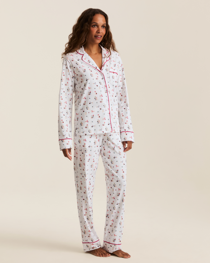 A woman modeling a two-piece pajama set with a white background and a whimsical puppy print