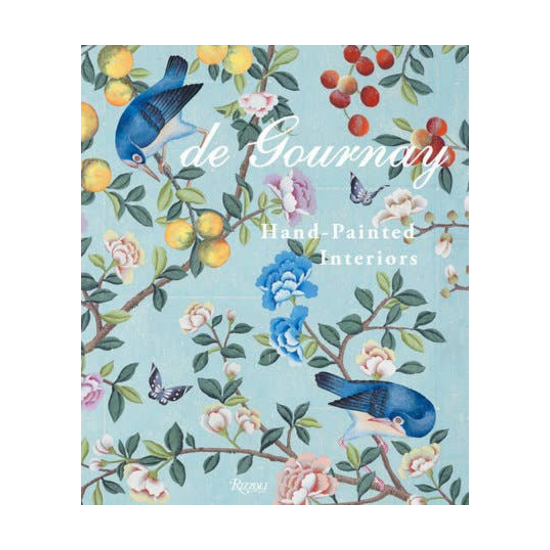 A book cover for 'de Gourmet' Hand-Painted Interiors, featuring a light blue background decorated with hand-painted botanical motifs including bluebirds, yellow lemons, pink and white flowers, and butterflies.