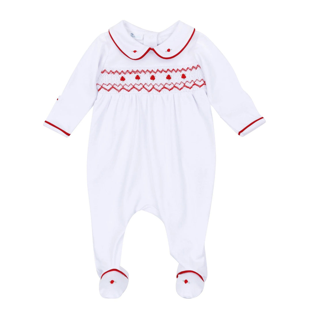 A white baby footed sleeper with long sleeves and a Peter Pan collar, featuring red embroidered patterns across the chest and red trim on the collar, cuffs, and feet.