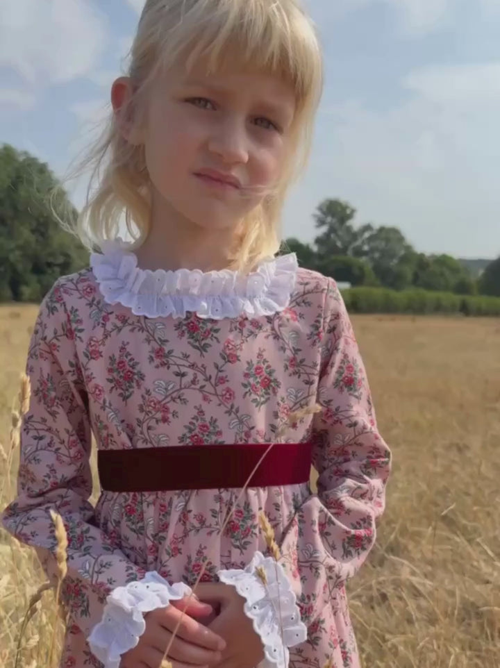 girl in pink romantic dress walking around a field
