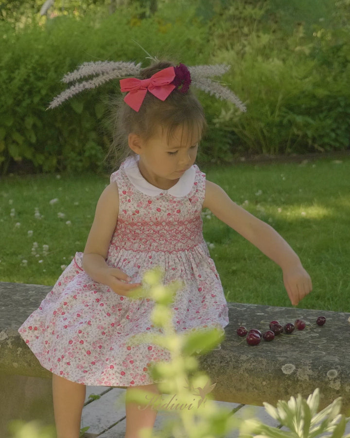 Girl Wearing Red Cherry Print Dress sitting on concrete bench