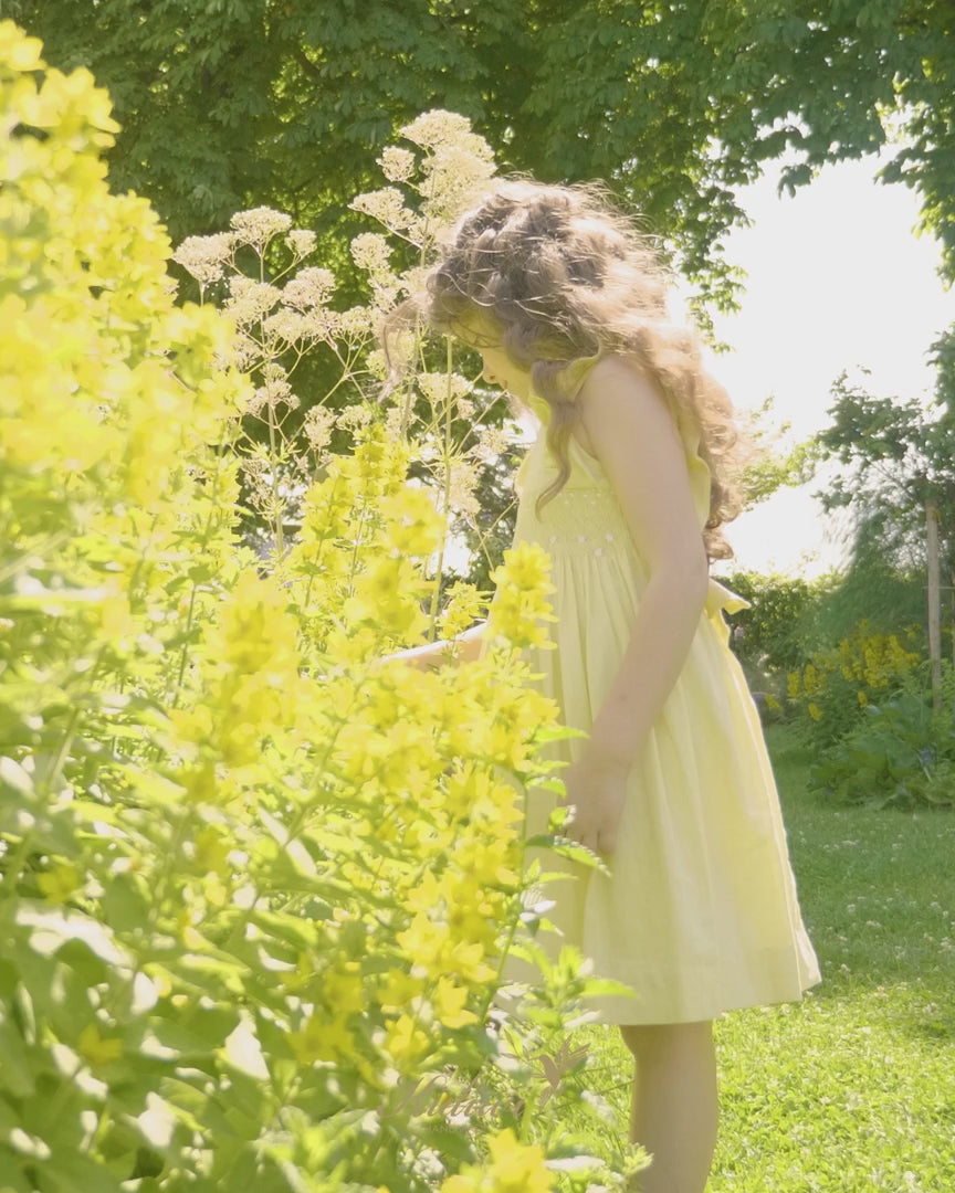 Girl In Yellow Linen Smocked Dress Near Yellow Flowers